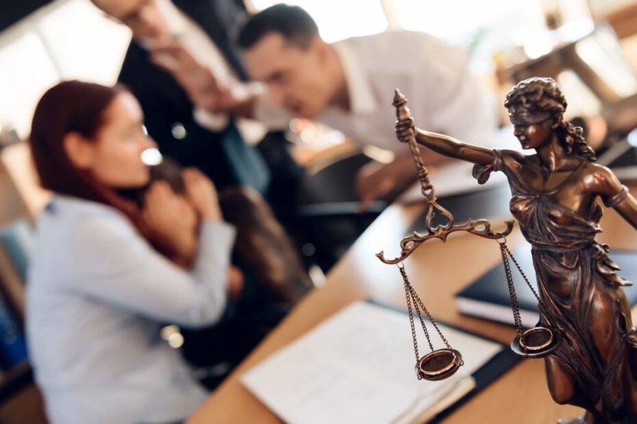 Ehepaar streitet vor einer Statue von Justitia