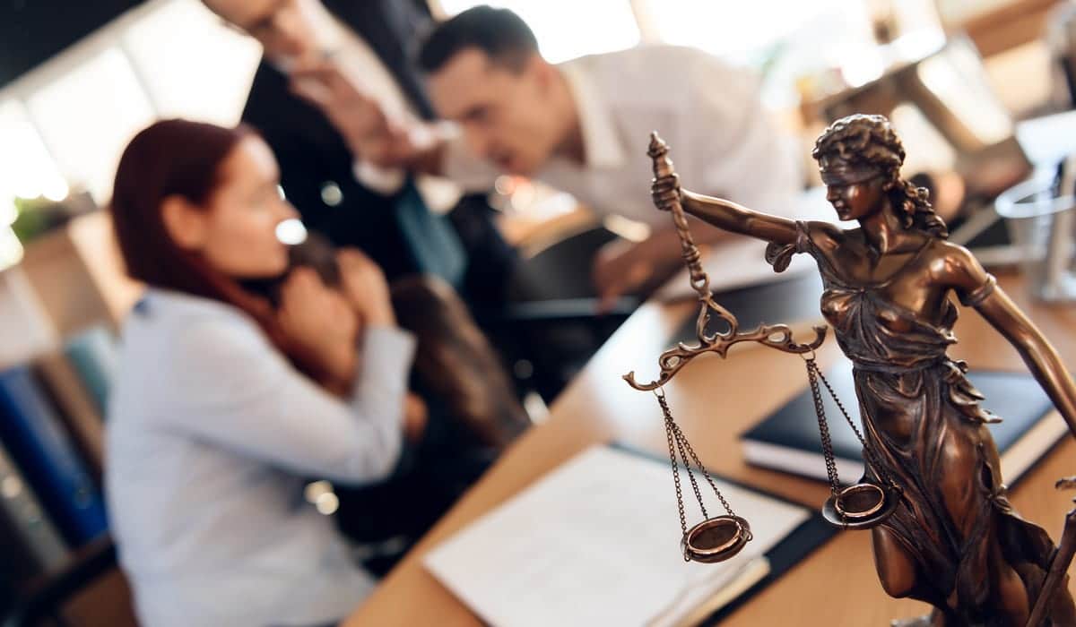 Ehepaar streitet vor einer Statue von Justitia