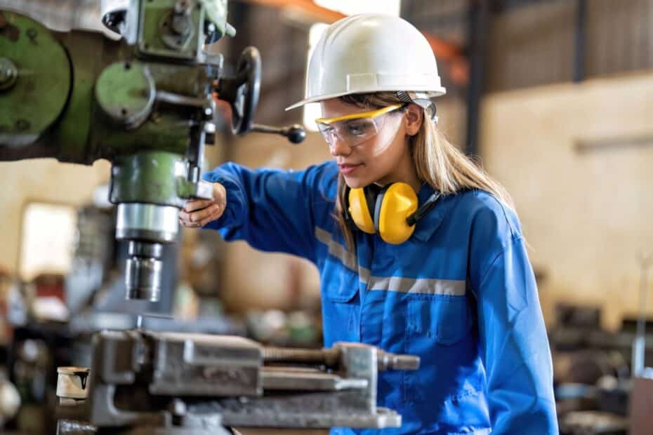 Auszubildende bei der Arbeit an einer Maschine in einem Ausbildungsbetrieb